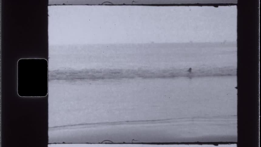 A person plays in shallow ocean water on a summer day