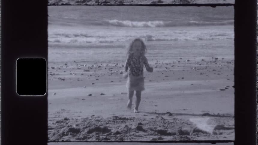 A young girl runs on the beach on a sunny summer day