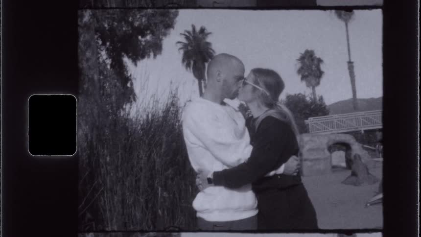 A couple kiss outside