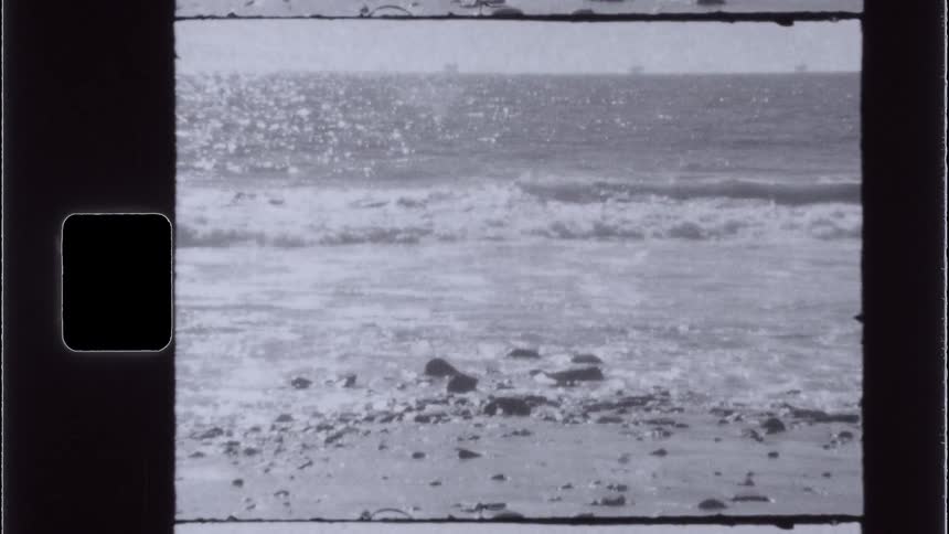 Small waves reach a beach that has rocks on it
