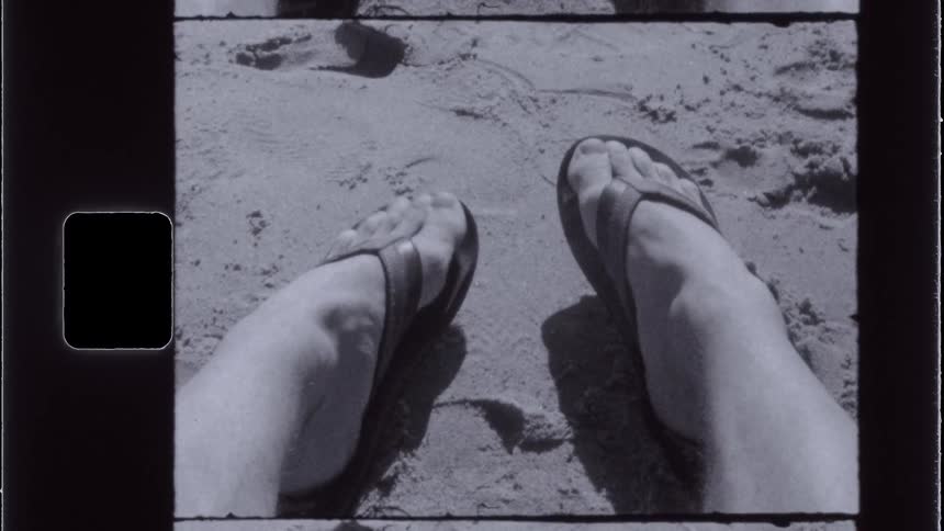 A person moves their toes on the sand