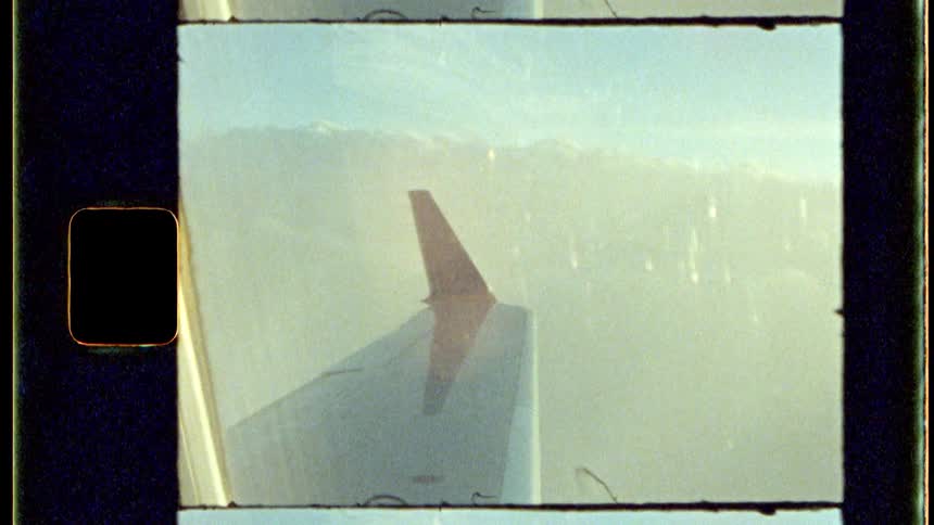 View of an airplane wing seen through the window in midflight