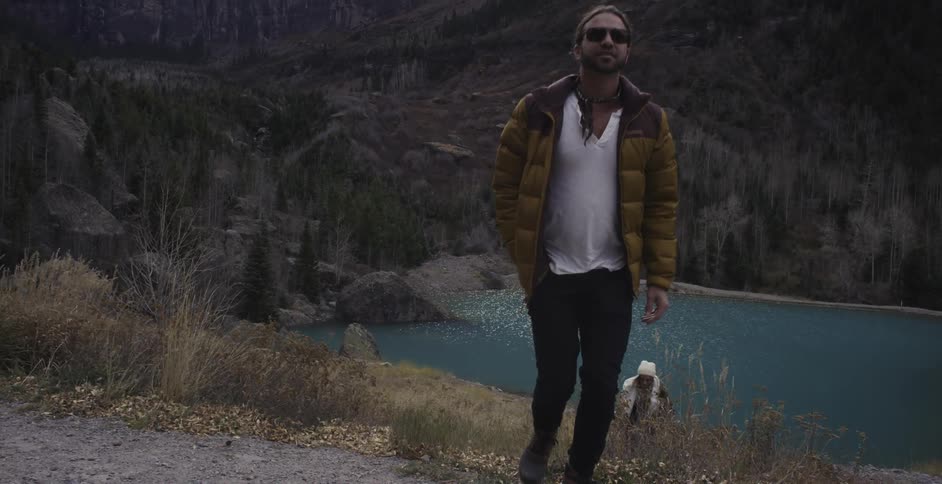 People are hiking uphill from a lake