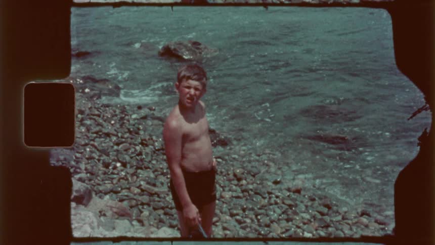 A boy is standing on the shore