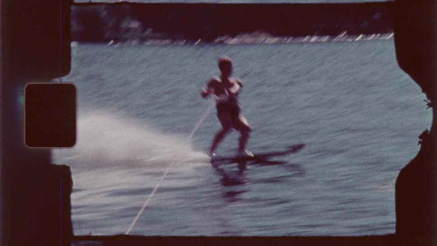 A man is wake surfing behind the boat