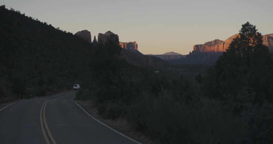 A vehicle parked on the side of a road in the mountains