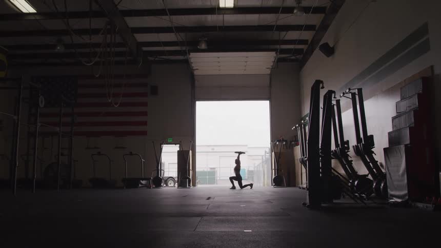 A woman is working out with a weight plate