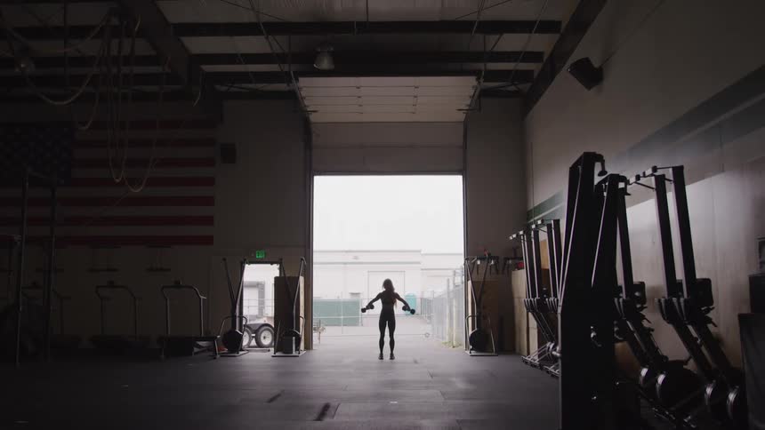 A woman is lifting weights in the gym