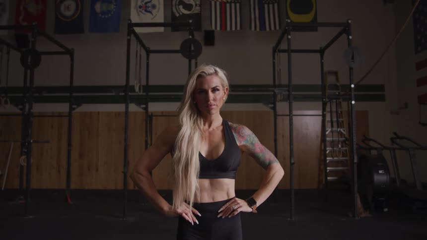 Tattooed and muscular woman in a black top at a gym