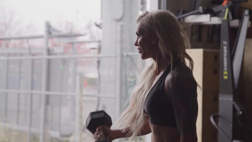 Blonde woman doing dumbbell biceps workout