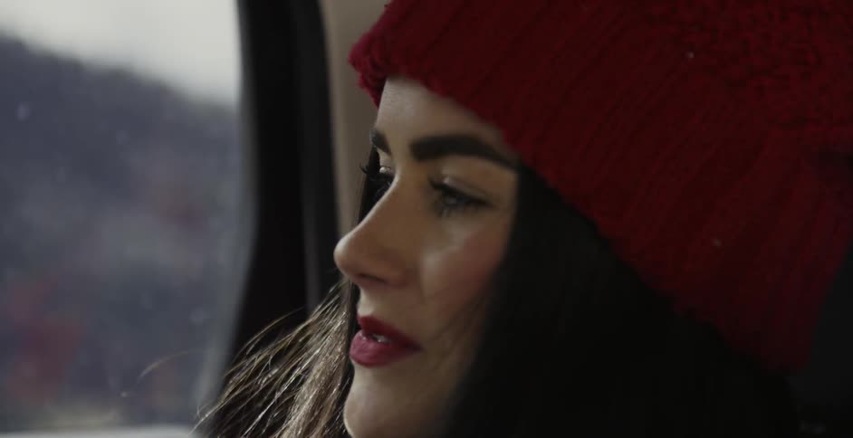 A female passenger smiles in a traveling car