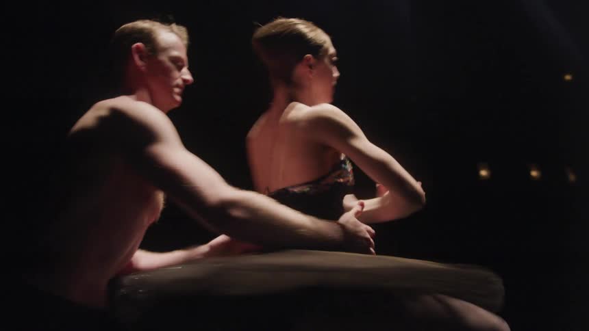 A man spins a ballerina around on stage in a duo performance