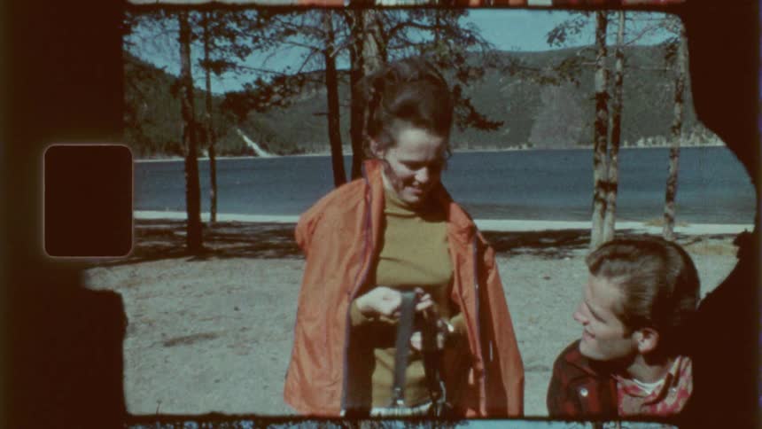 Woman standing next to a man outdoors adjusting a bag in his hand