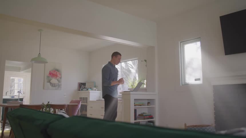 A man is talking on his laptop at home