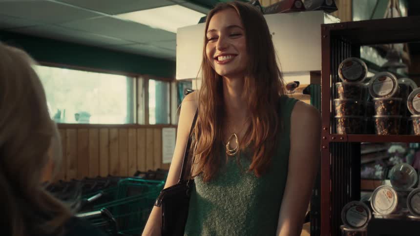 Smiling woman talking to another person in an indoor space