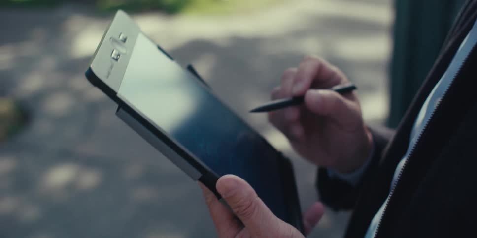A man is using a stylus on her tablet