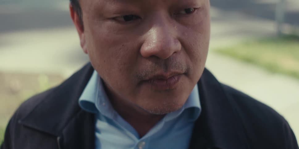 A man stands on a neighborhood street writing on a tablet with a stylus