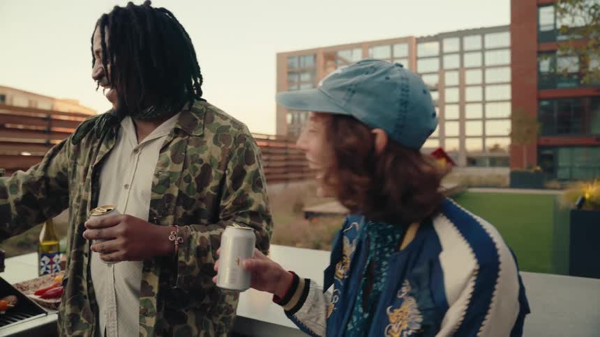 Man toasting beer with a woman while having a barbecue