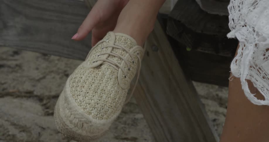 Woman untying and taking off her shoe