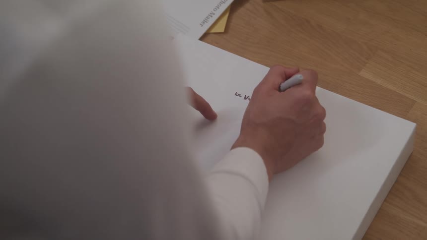 A person is using a pen to write on paper