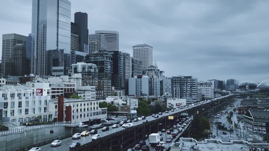 Congested traffic travels along a metropolitan highway on a cloudy summer day
