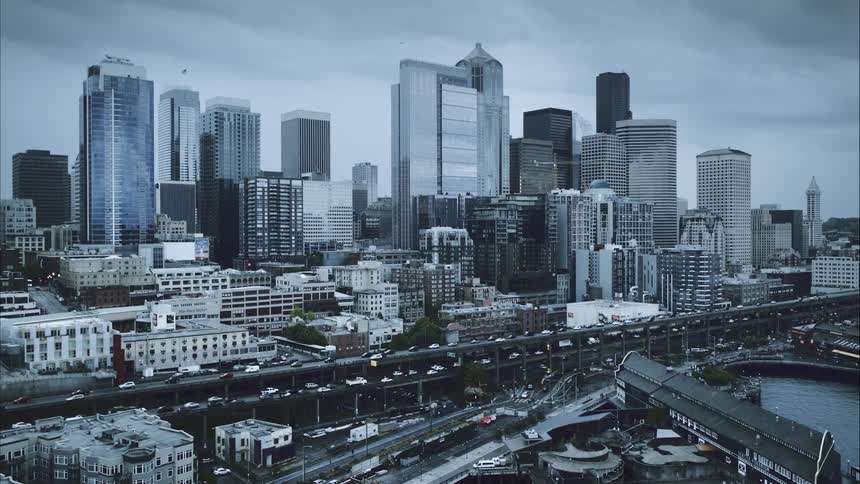 Traffic moves on a highway in a city with skyscrapers