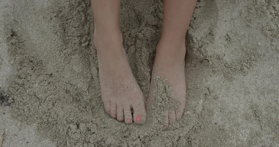 Woman moving her foot in the sand