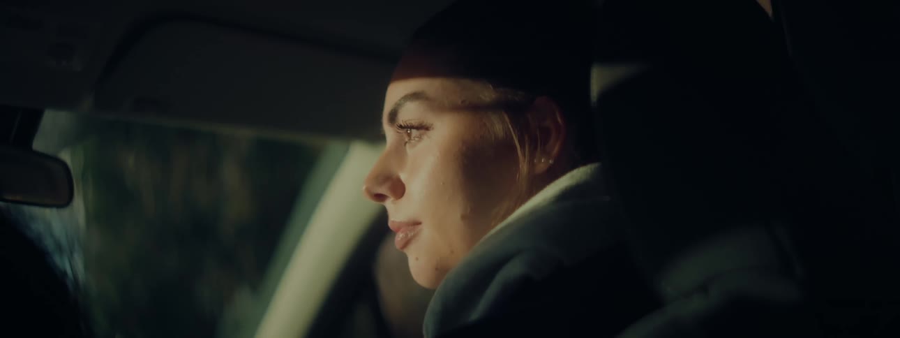A woman looks sad as she sits in her car