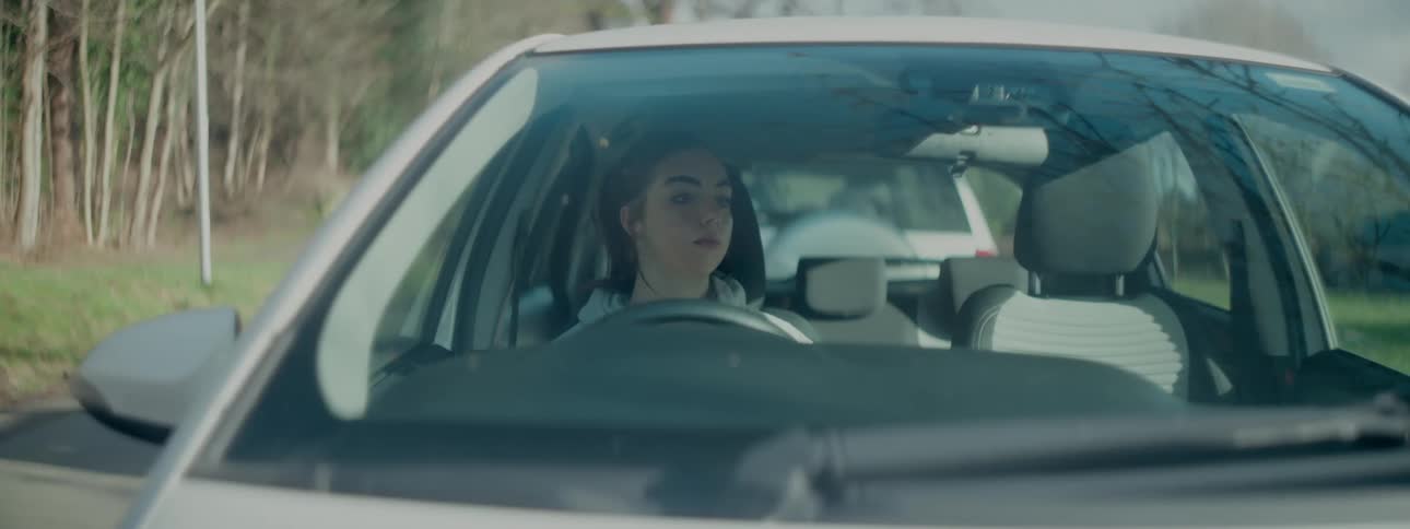 A woman sits behind the wheel of a car