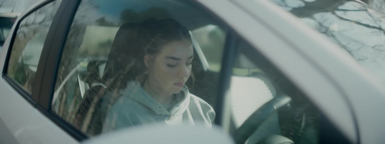 A teenager is sitting in the car