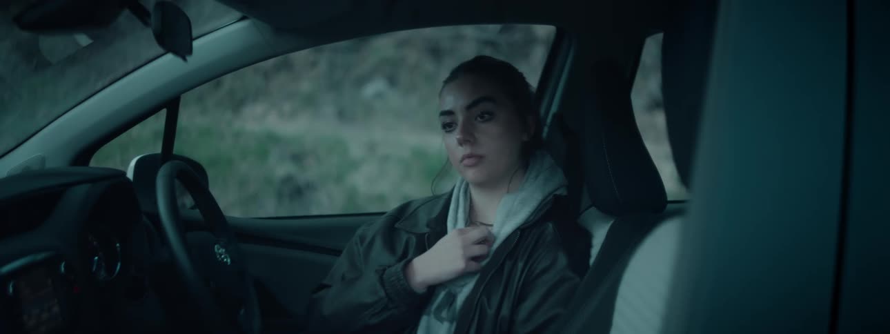 A woman is sitting in a car and thinking