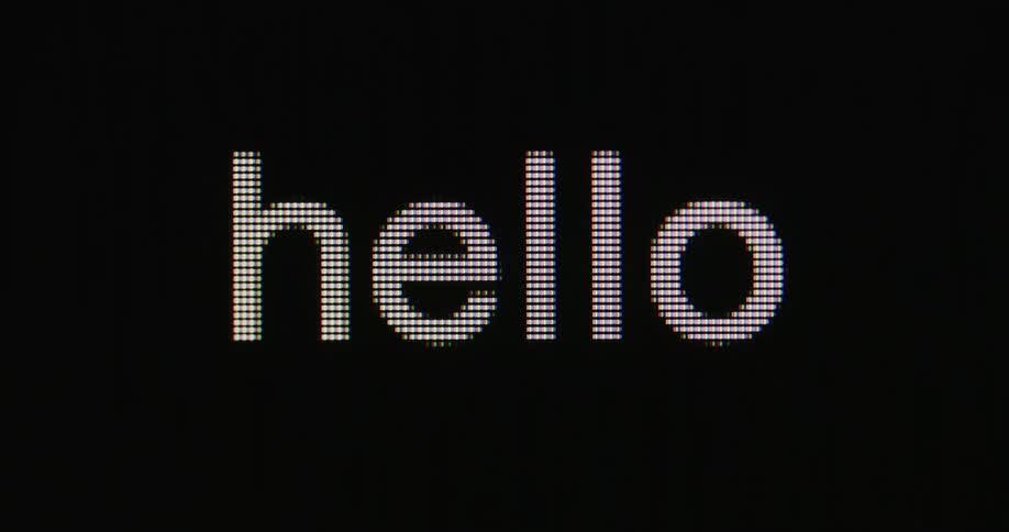 Seen in closeup the word hello is typed across a dark lcd screen with each led diode clearly visible as the letters appear in crisp sharp detail and a small blinking cursor completes the display