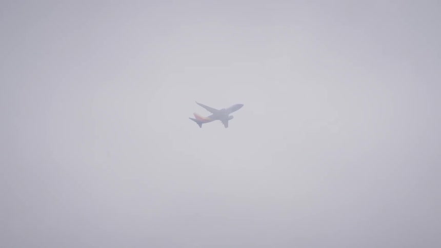 Commercial airplane flying in a cloudy sky
