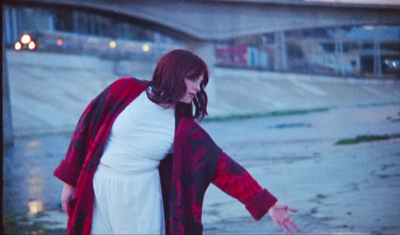 A woman stretches her arm out in the canal