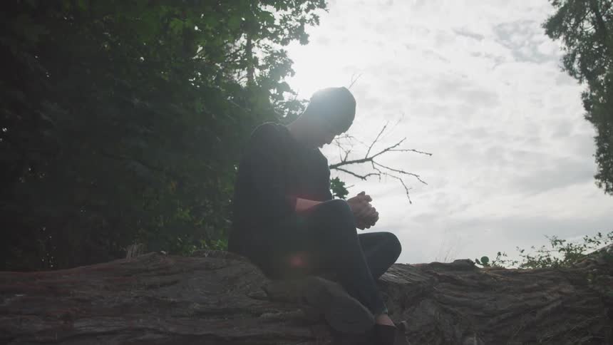 A man sitting on a fallen tree