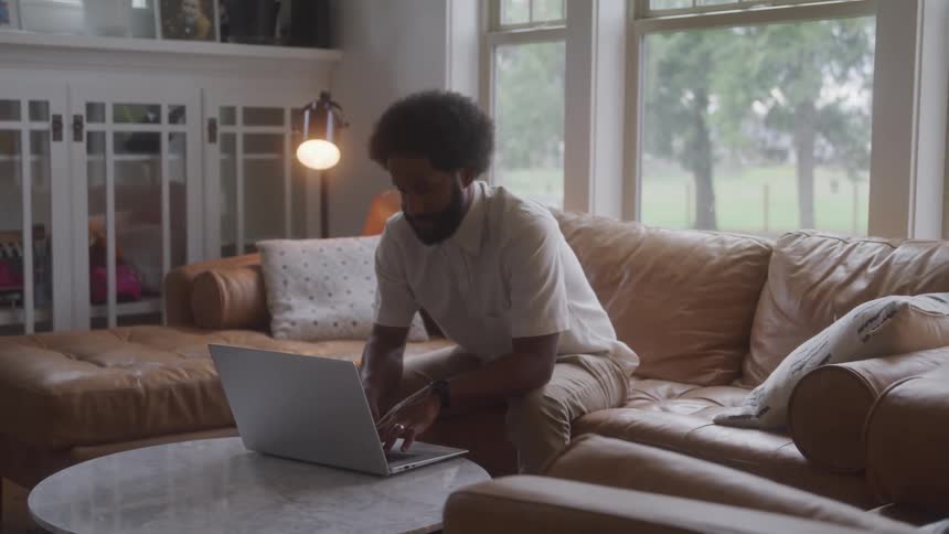 Man sitting in front of a laptop looking thoughtful