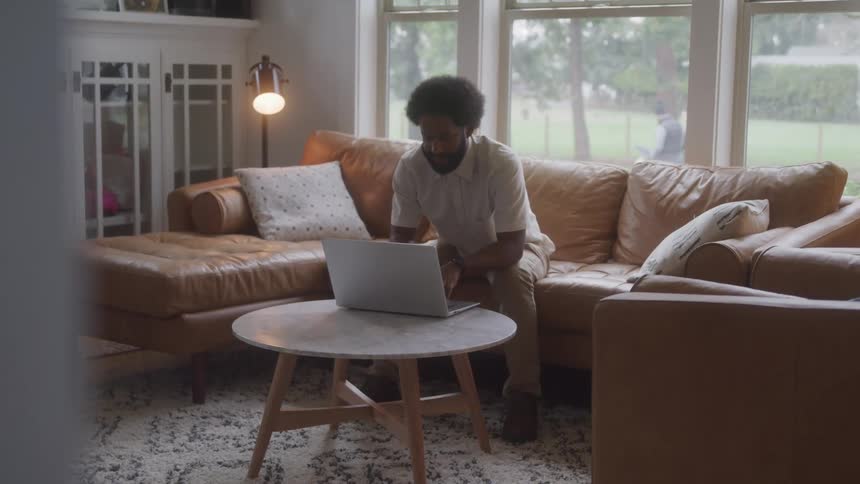 A man is using his laptop at home