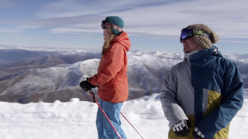 Three people ski and snowboard down a mountain