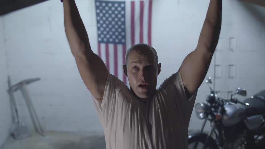 Man doing pullups while standing in a garage
