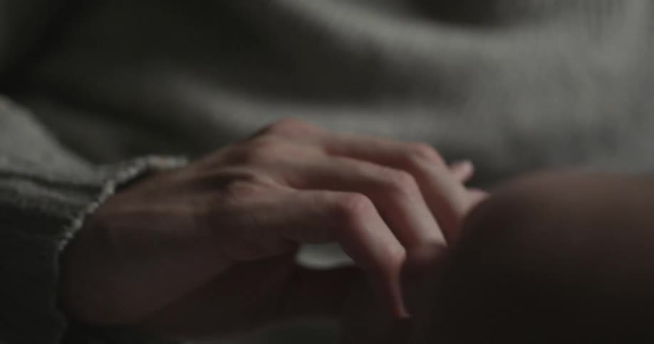 A man holds a baby's hand