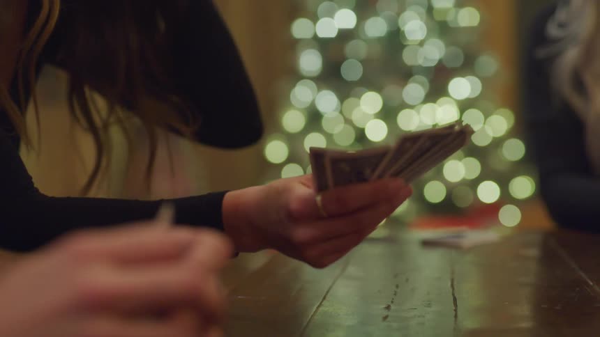 Womens hands on a table playing cards