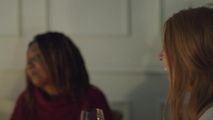Two women laughing while sitting at a table