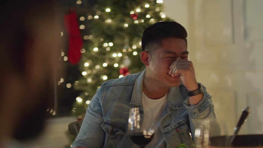 Man sitting at a table laughing out loud
