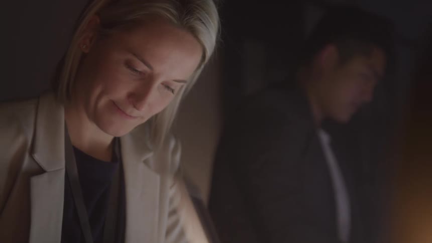 Portrait of a blonde woman working in a dark room with other colleagues