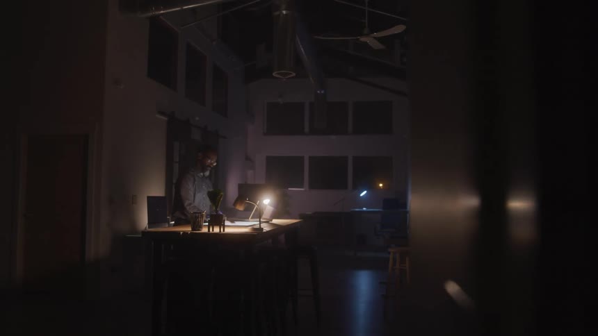 A man is working in the dark office