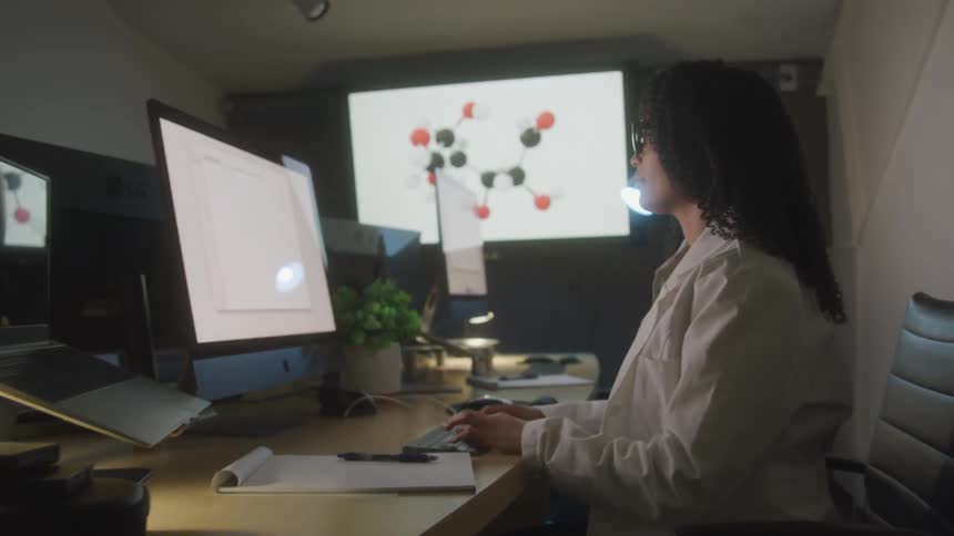 A woman is working at the computer in the office
