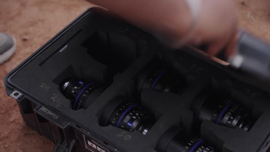A person puts a camera lens back in the case
