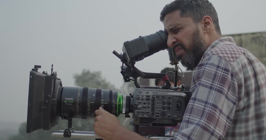 Male filmmaker carrying a professional camera