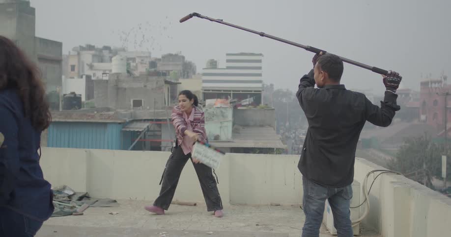 People taking part in a film shoot in a precarious outdoor city