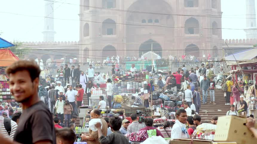 Openair market with a crowd of people in front of a shrine